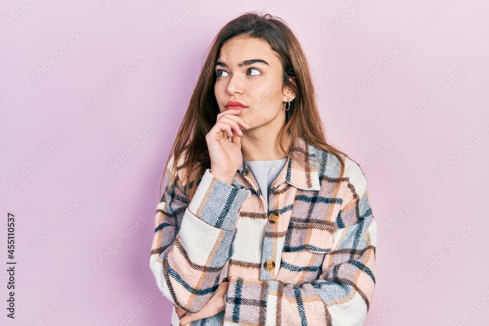 Young caucasian girl wearing casual clothes with hand on chin thinking about question, pensive expression. smiling with thoughtful face. doubt concept. Young caucasian girl wearing casual clothes with hand on chin thinking about question, pensive expression. smiling with thoughtful face. doubt concept.
