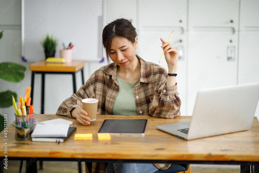 Portrait of asian young woman working on computer at table in office, Portrait of asian young woman working on computer at table in office,