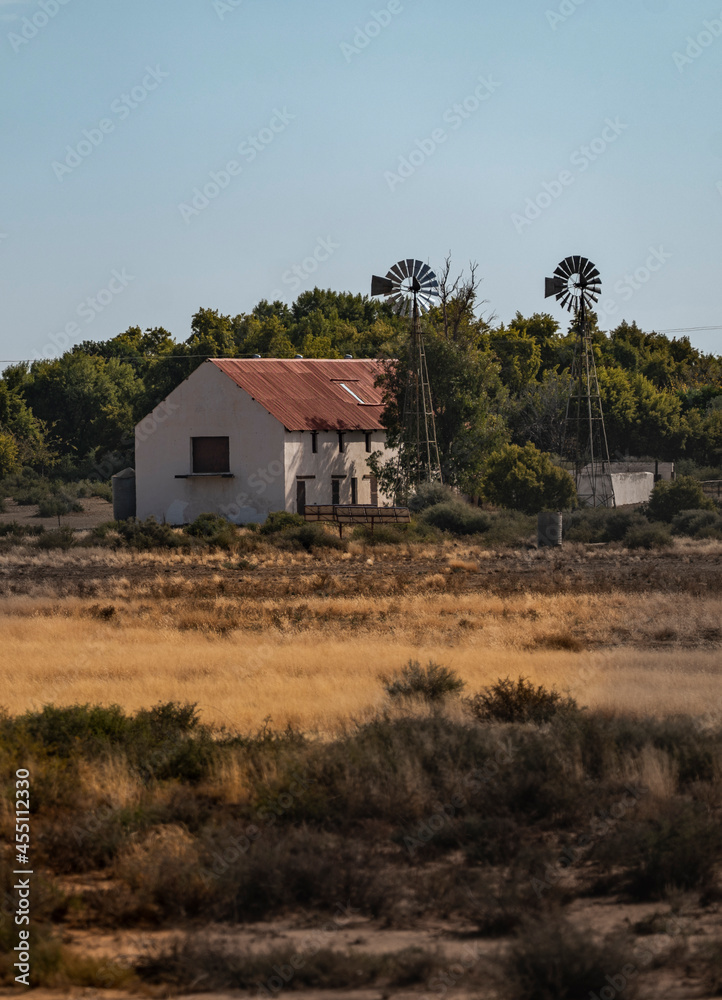 A portrait shot of a rustic house and windmill in Karoo desert during winter vegetation shot of rustic abundant house and windmill in Karoo desert during winter vegetation A portrait shot of a rustic house and windmill in Karoo desert during winter vegetation shot of rustic abundant house and windmill in Karoo desert during winter vegetation