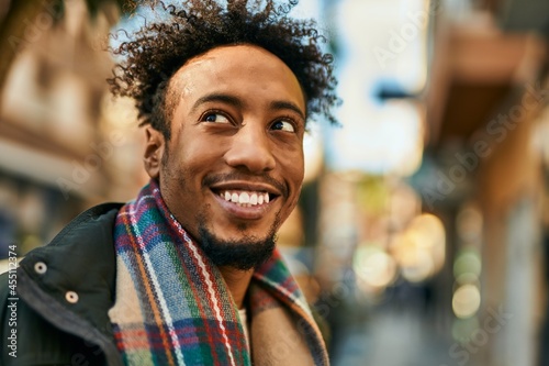 Young african american man smiling happy standing at the city