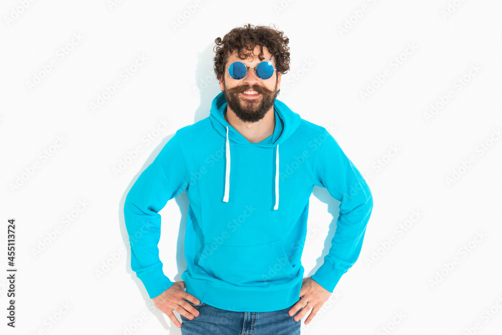casual man wearing sunglasses, holding his hands in his hips casual man wearing sunglasses, holding his hands in his hips