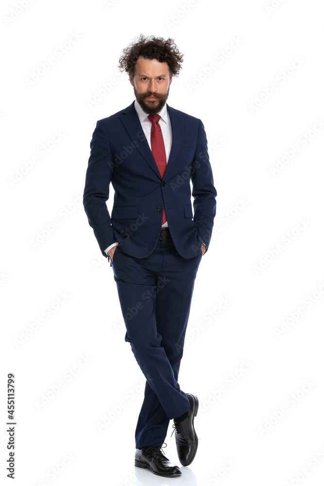businessman crossing his legs and holding his arms in pockets