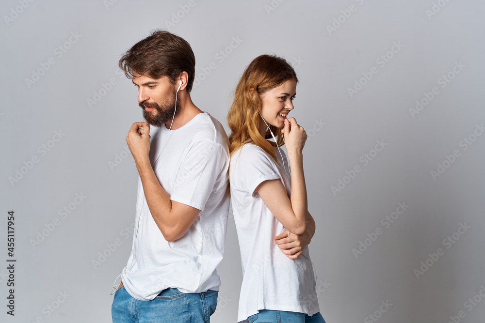 cheerful young couple in white t-shirts with headphones listening to music joy friendship cheerful young couple in white t-shirts with headphones listening to music joy friendship
