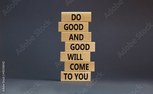 Concept of karma motivational words. Wooden blocks on the stack of wooden blocks. Words 'do good and good will come to you'. Beautiful grey background, copy space.