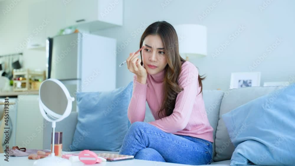 Asian frustrated attractive women make up herself in hurry in house. Asian frustrated attractive women make up herself in hurry in house.