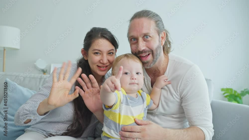 Caucasian Parents with little baby boy video call online with family.