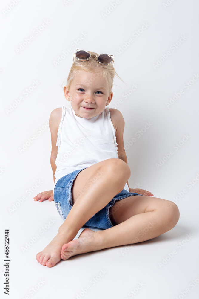 Smiling child in a tank top with sunglasses on a light background Smiling child in a tank top with sunglasses on a light background
