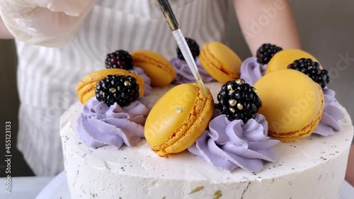 Professional confectioner decorating cake with gold. The process of cooking. 4K. Violet and orange. Close up. Step 5