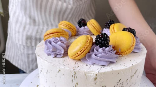 Professional confectioner decorating cake with blackberry. The process of cooking. 4K. Violet and orange. Close up. Step 4