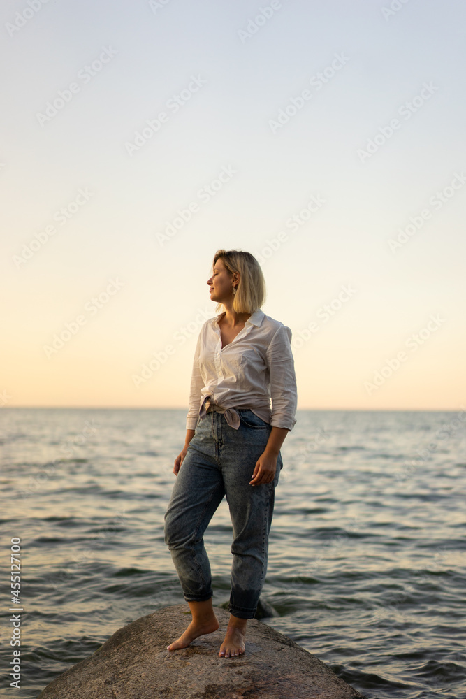 Portrait of middle aged woman standing at the beach at sunset Portrait of middle aged woman standing at the beach at sunset