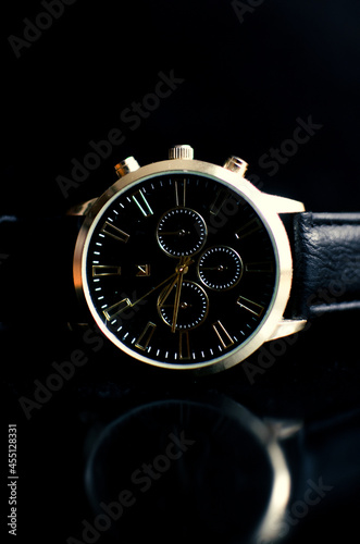 Reloj en fondo negro con tonos dorados 