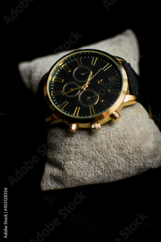 Reloj con tonos dorados en fondo negro 