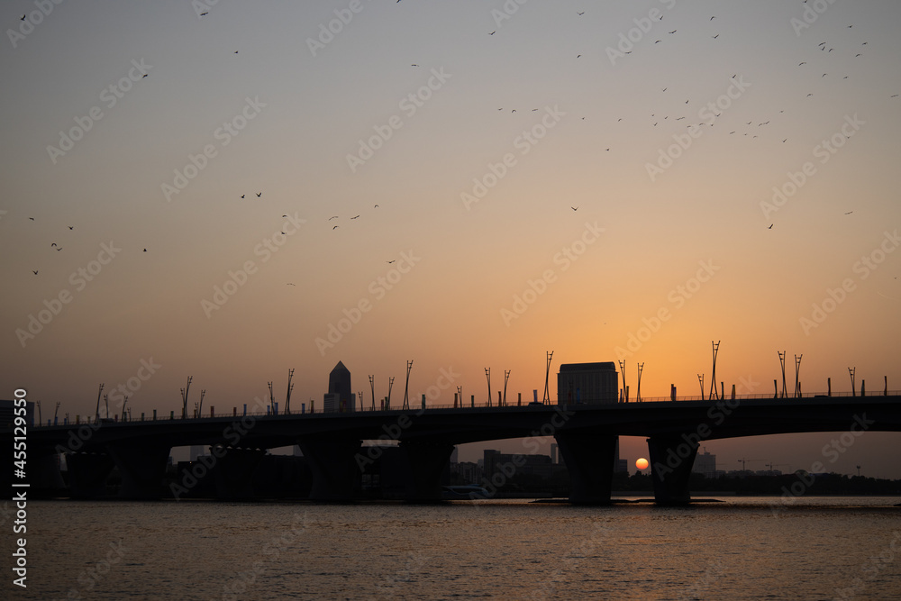 Silhouette of a bridge on a lake in Dubai at sunset 