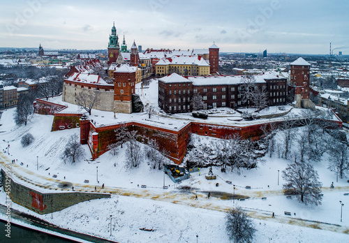 Krakow, Poland. Historic royal Wawel Castle and Cathedral in winter with white snow, walking people and promenade.