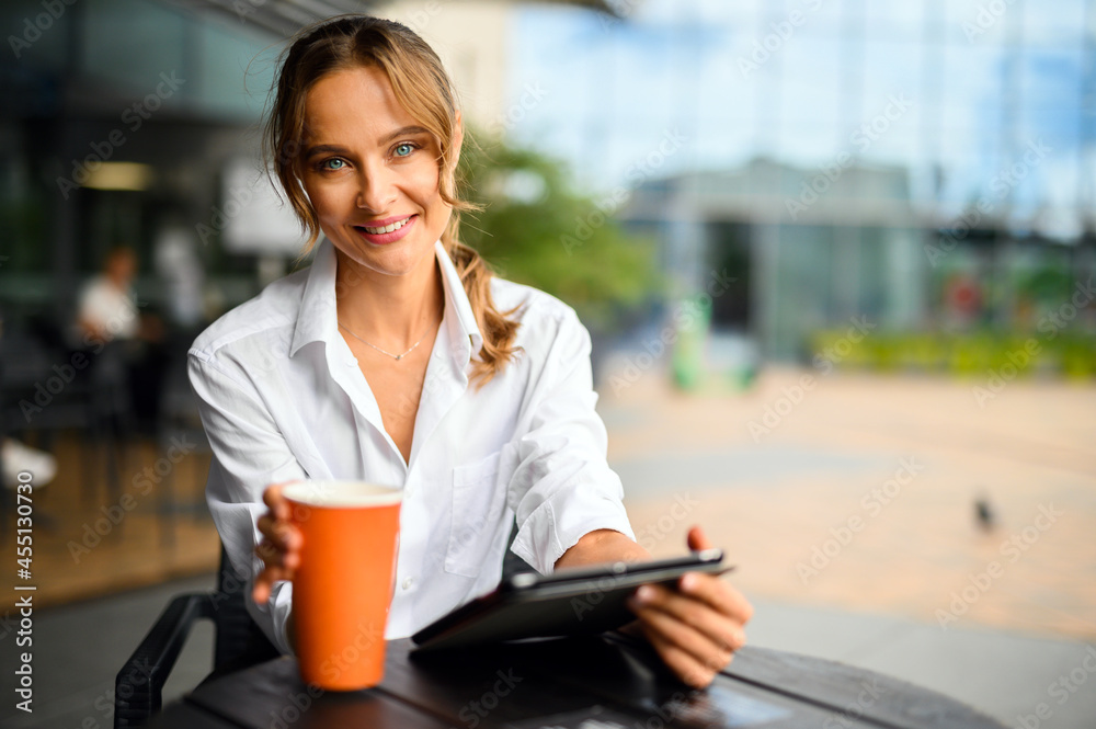 Young businesswoman on a coffee break, smiling at camera Young businesswoman on a coffee break, smiling at camera