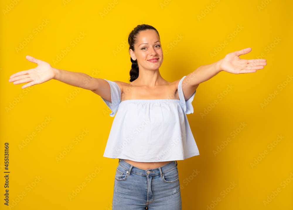 Young beautiful woman giving a hug isolated over yellow background. Young beautiful woman giving a hug isolated over yellow background.