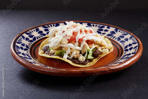 Tostadas de pollo con frijoles, crema, queso y verduras