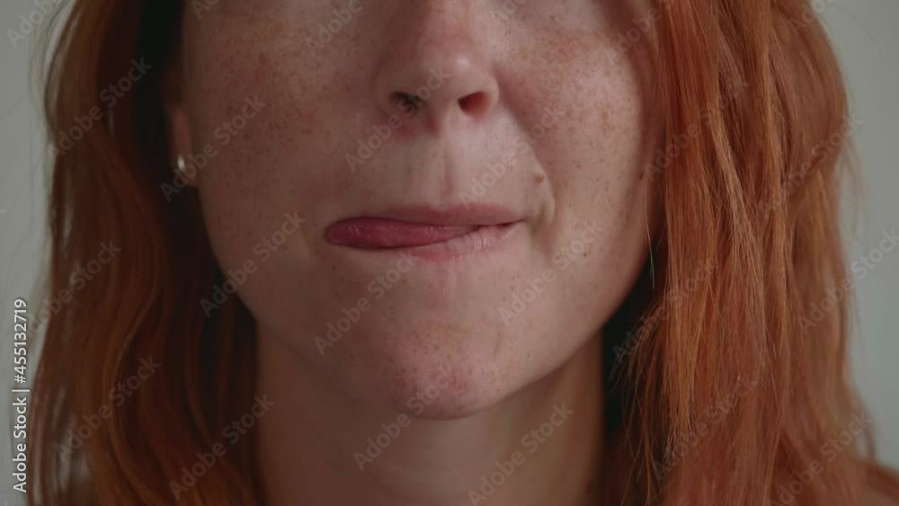An attractive young girl with red hair, licking her lips. An attractive young girl with red hair, licking her lips.