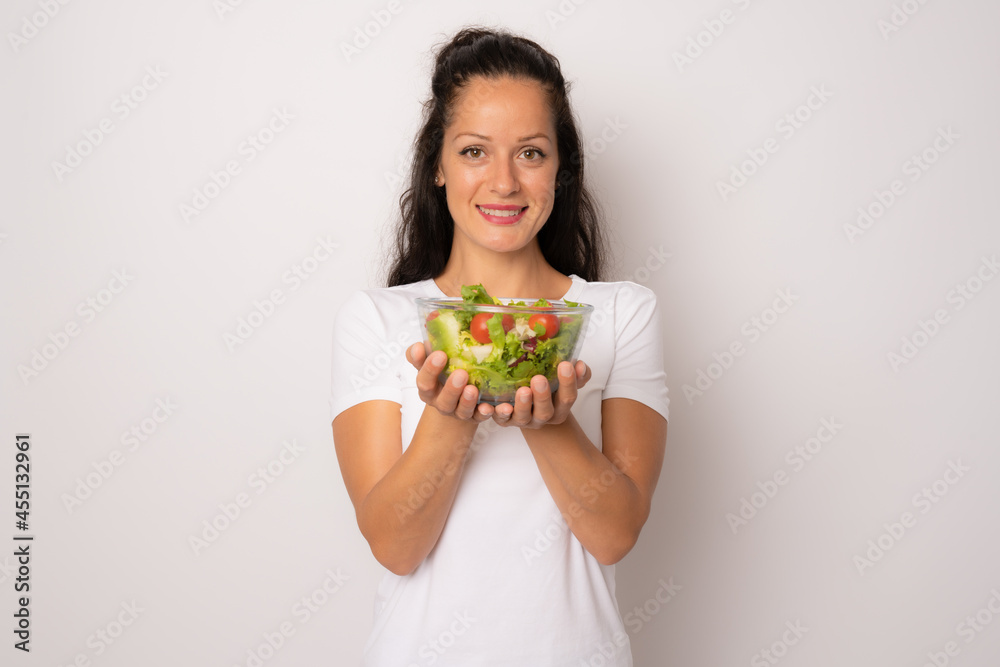 Young woman eating a healthy salad isolated over white background. Young woman eating a healthy salad isolated over white background.