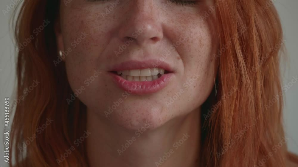 An attractive young girl with red hair, licking her teeth. An attractive young girl with red hair, licking her teeth.