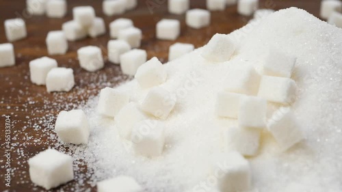 white granulated sugar and refined sugar on brown wooden surface