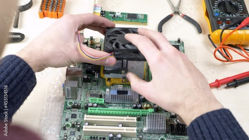 young man installing cpu cooler fan on motherboard engineer assembling 
