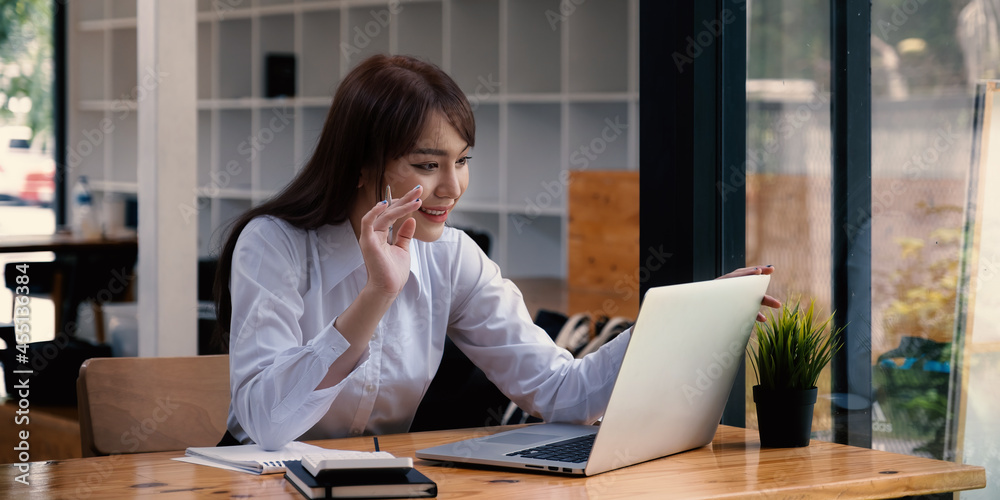 Cheerful young asian woman using laptop computer at home. Student female in living room. online learning, studying , online shopping, freelance, asean concept Cheerful young asian woman using laptop computer at home. Student female in living room. online learning, studying , online shopping, freelance, asean concept