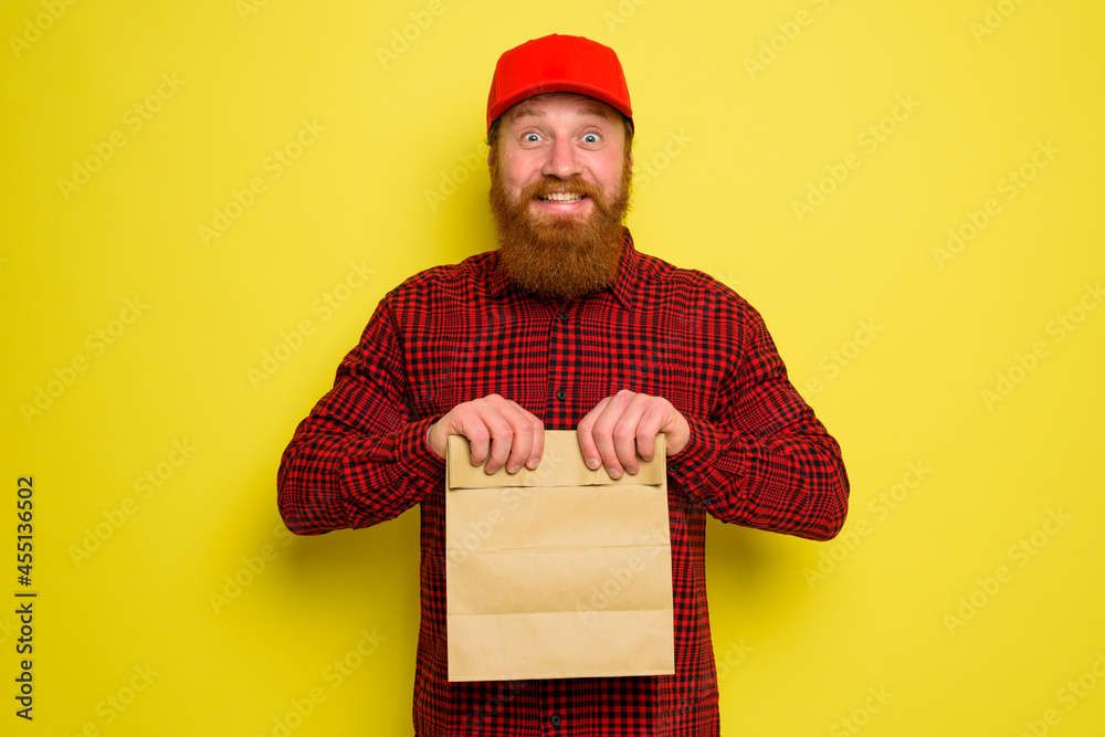 Delivery man with hat and beard has an happy expression