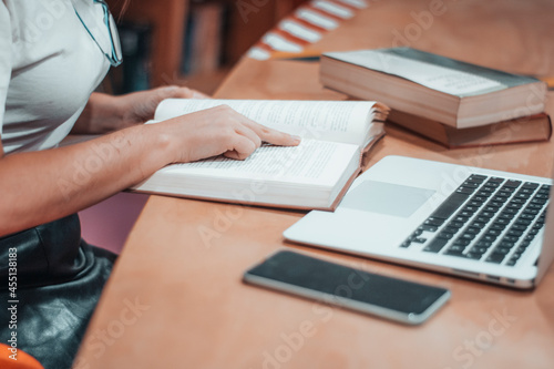 Fotografía Niña estudiante tomando una lectura y apuntes en la biblioteca municipal para ap