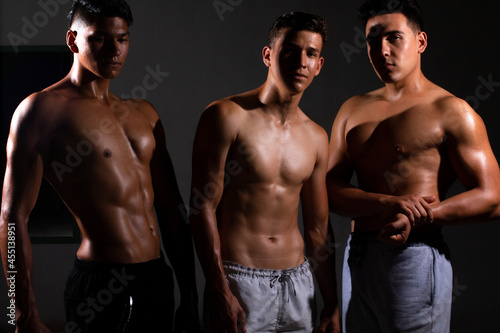 Three strong and fit latin men bodybuilders. Sporty muscular men posing. Sports and fitness motivation. Individual sports recreation. photo