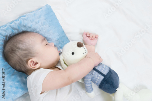 Selective focus portrait of a sleeping Charming baby Cute newborn sleeps with a toy teddy bear on comfortable bed