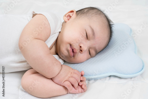 Sleeping baby, selective focus portrait of charming newborn on comfortable bed