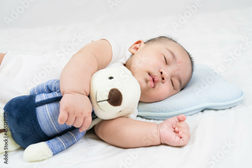 Selective focus portrait of a sleeping Charming baby Cute newborn sleeps with a toy teddy bear on comfortable bed