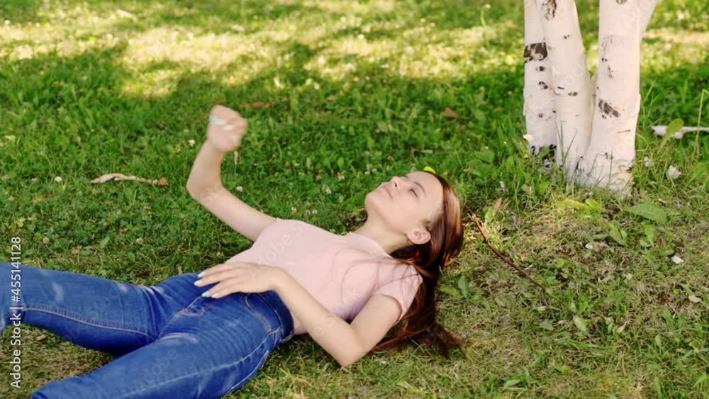 happy student is lying on the grass, smiling, laughing, summer holidays and weekends in the park happy student is lying on the grass, smiling, laughing, summer holidays and weekends in the park