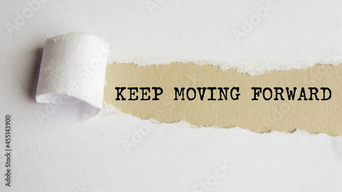 keep moving forward. words. text on grey paper on torn paper background