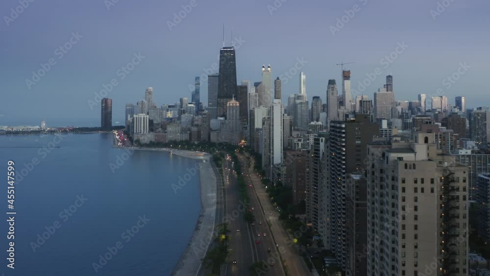 Chicago Downtown night scene at dusk with pastel blue sunset sky on motion background. Chicago aerial shot with busy road and modern waterfront skyscraper buildings. 4K footage USA Illinois city Chicago Downtown night scene at dusk with pastel blue sunset sky on motion background. Chicago aerial shot with busy road and modern waterfront skyscraper buildings. 4K footage USA Illinois city