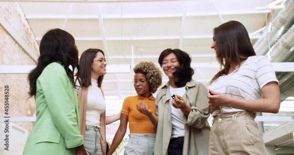 Group of smiling multiethnic women talking to each other in an office Group of smiling multiethnic women talking to each other in an office