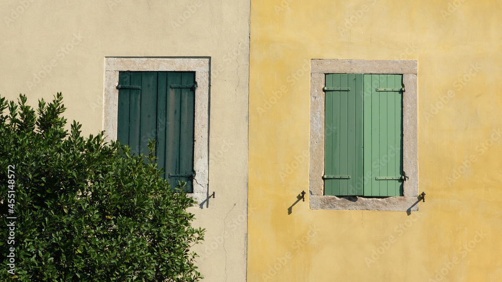 An italian yellow house with green shutters