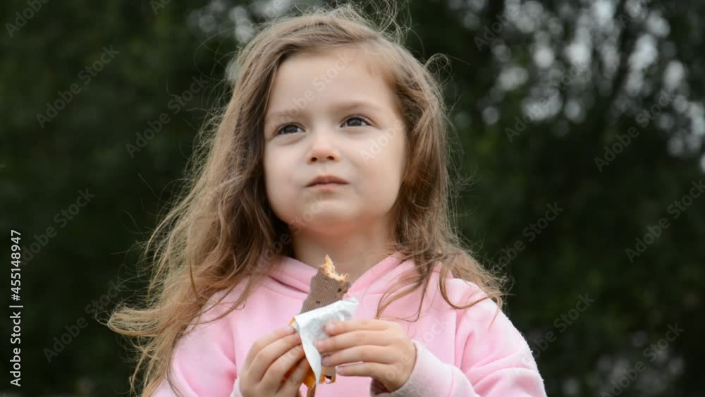 Portrait of a beautiful little girl eating chocolate candy Portrait of a beautiful little girl eating chocolate candy