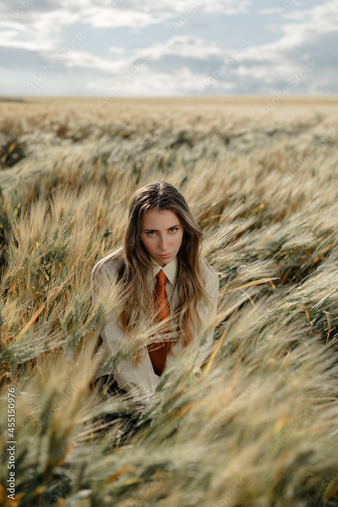 Millennial woman among wheat spikes in field Millennial woman among wheat spikes in field