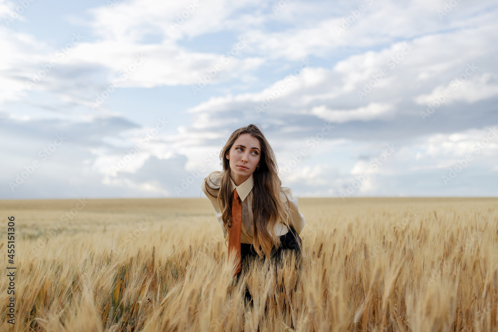 Millennial woman among wheat spikes in field Millennial woman among wheat spikes in field