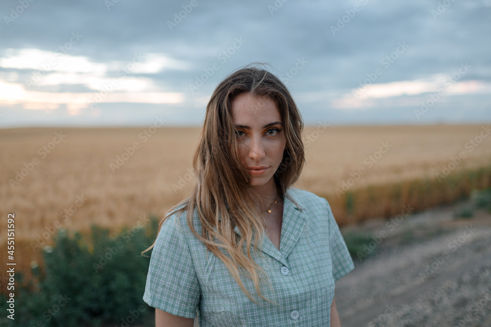 Stylish model in field under cloudy sky Stylish model in field under cloudy sky