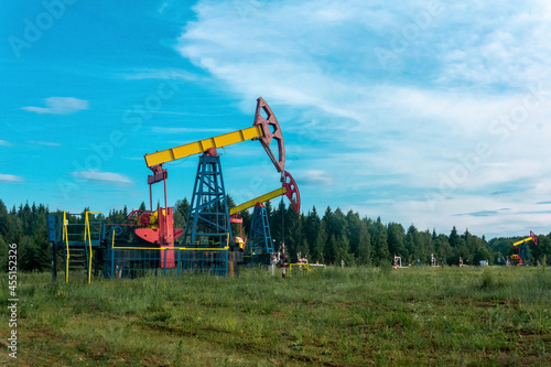 oil pumpjacks in a clearing in the forest