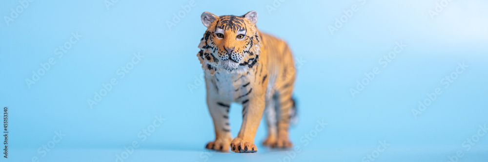 the tiger, symbol of 2022 year. plastic orange toy figure tiger on a blue  background. banner Stock Photo | Adobe Stock
