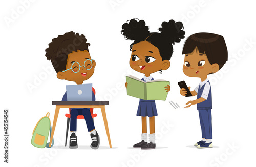 Funny multiracial dark skin primary pupils smiling talking together vector flat illustration. Cute schoolgirl and schoolboy wearing trendy school uniform use book, laptop and smartphone isolated