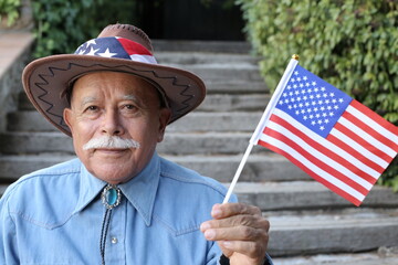 Senior American cowboy holding the national flag
