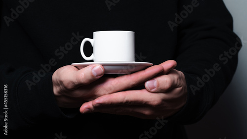 A coffee mug in men's hands. 