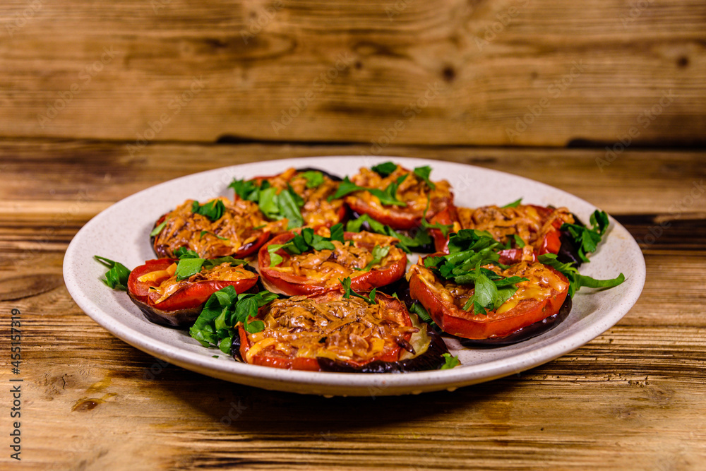 Baked eggplants with tomatoes and cheese in a ceramic plate