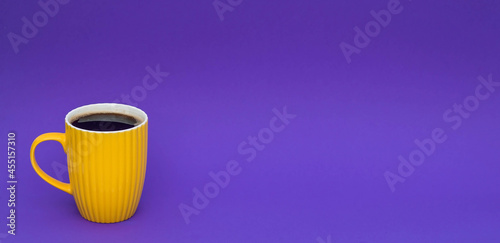 Yellow coffee cup on a fashionable purple background. The concept of the word "Happy Friday".