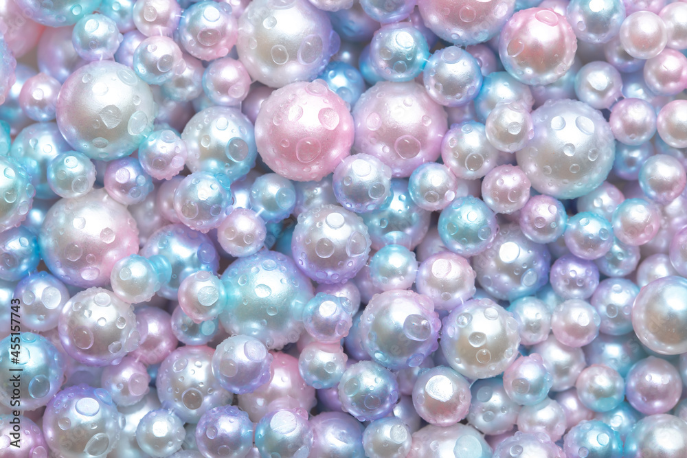 Beautiful background with pearl pearls, top view. Abstract texture for festive backgrounds. Shiny surface of Christmas decorations. Gems close-up. Multicolored bright background.